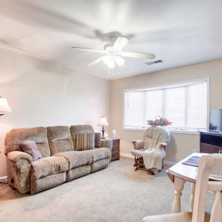 A cozy living room with a sofa, armchair, and ceiling fan.