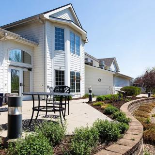 A modern house with a spacious patio featuring outdoor seating and landscaped garden.