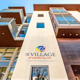 A modern building exterior showcasing The Village at Hayes Valley.