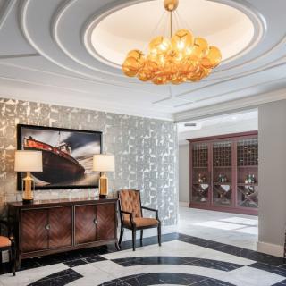 A luxurious foyer with an elegant chandelier and stylish furniture.