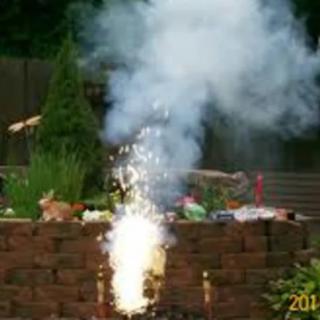 A garden fireworks display with smoke and sparks.
