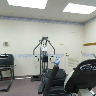 A small gym with various exercise equipment.
