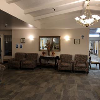 A cozy lobby area with sofas, a decorative mirror, and soft lighting.