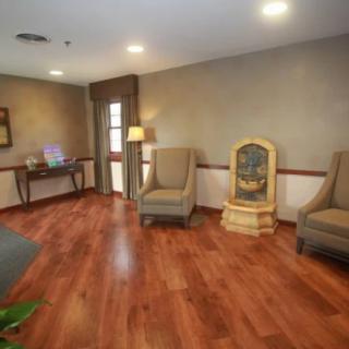 A cozy waiting room with comfortable chairs and a hardwood floor.