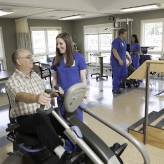 A patient engages in physical therapy with the assistance of a healthcare professional in a rehabilitation center.