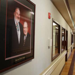 A hallway featuring a framed portrait of two individuals on the wall.
