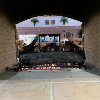 A warm and inviting view of a fireplace with glowing embers and stacked wood.