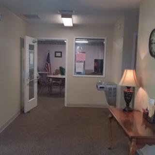 A glimpse into an office space featuring a welcoming ambiance with furniture and a water fountain.
