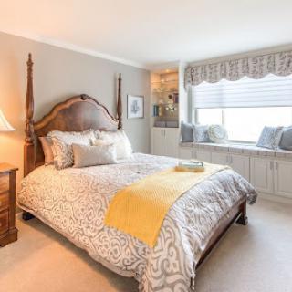 A cozy and inviting bedroom featuring elegant furnishings and a sunlit window seat.