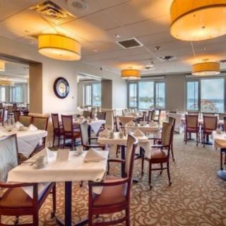 A well-lit restaurant dining area with neatly arranged tables and chairs.