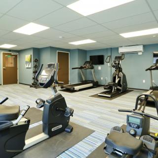 A modern gym with various exercise equipment, including treadmills and stationary bikes.