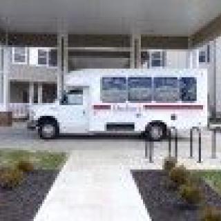 A small bus parked in front of a building entrance.
