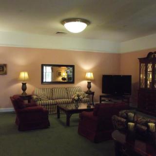 A cozy living room with a sofa, armchairs, and a television.