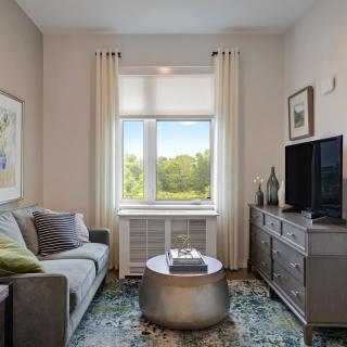 A cozy living room featuring a sofa, television, and a central coffee table with decor.