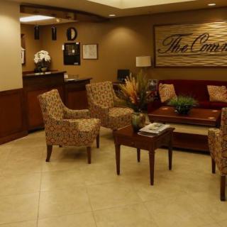 A cozy waiting room with patterned chairs and a central table adorned with flowers.