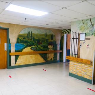 A vibrant mural depicting a serene landscape on the wall of a hallway.
