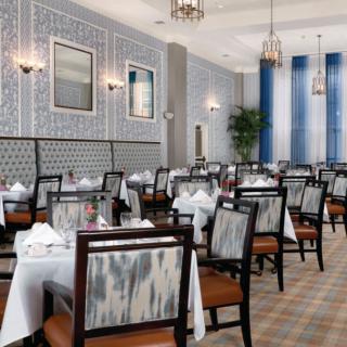 An elegantly designed restaurant dining room featuring neatly arranged tables and chairs.