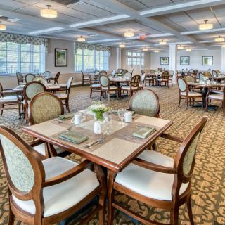 An elegant dining room with neatly arranged tables and chairs, featuring a formal interior design.