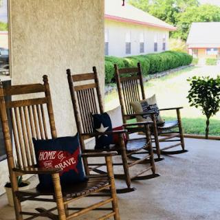 A serene porch with rocking chairs inviting relaxation on a sunny day.
