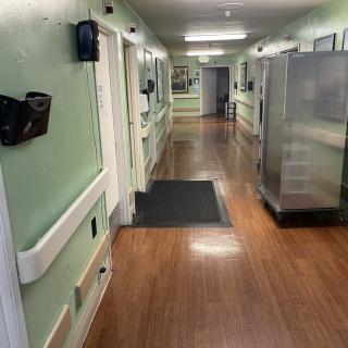 A hospital hallway with medical equipment and doors on either side.