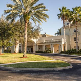 A hotel entrance surrounded by palm trees and well-maintained landscaping.