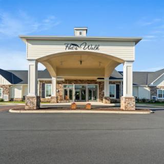 A large building with a grand entrance and clear blue skies.