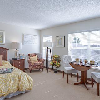 A cozy bedroom with elegant furniture and ample natural light.