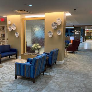 A modern lobby with comfortable seating and decorative elements on the wall.