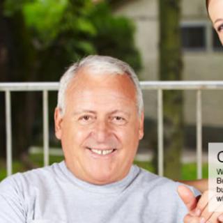 A smiling elderly man sitting outdoors in a casual setting.