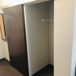 An empty minimalist closet with a single hanging rod.
