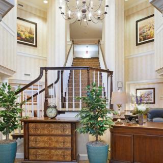 Elegant lobby with a grand staircase and sophisticated decor.