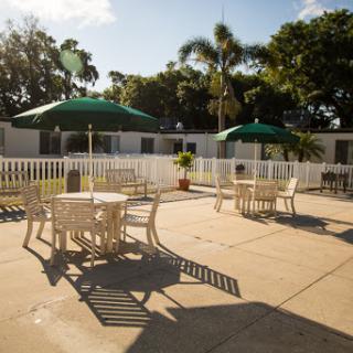 A serene outdoor pool area with tables and umbrellas, perfect for relaxation under the sun.