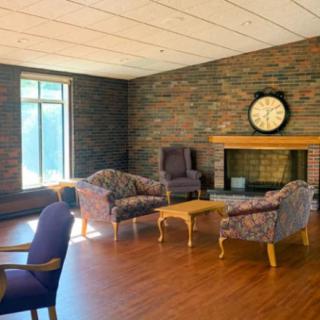 A cozy living room with a brick wall, fireplace, and comfortable seating.