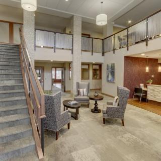 A modern hotel lobby with seating area and a reception desk.