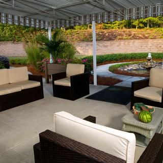 A cozy outdoor patio with comfortable seating and a landscaped garden.