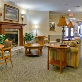 A cozy lobby interior with seating, tables, and a fireplace.