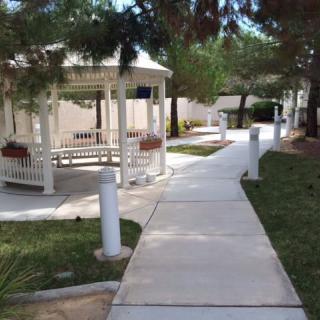 A peaceful outdoor pathway with a gazebo surrounded by greenery.