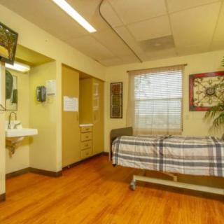 A hospital room with a single bed and medical amenities.