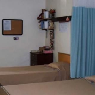 A hospital room with two beds separated by a curtain, creating a simple and functional healthcare environment.