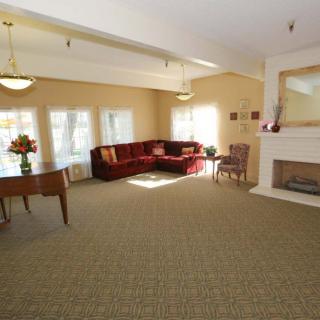A spacious living room with a red corner sofa and a fireplace.