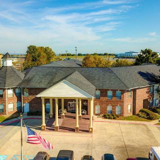 Aerial view of a brick hotel with a prominent entrance and parking area.