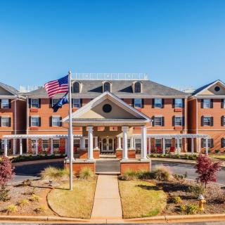 Exterior view of a hotel building with an American flag in front.