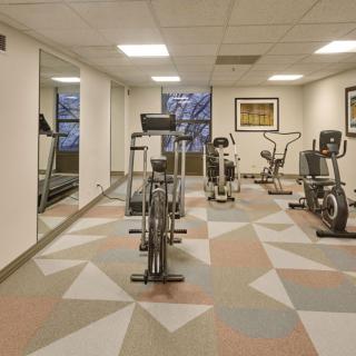 A modern gym with various exercise equipment and mirrors for an indoor workout.