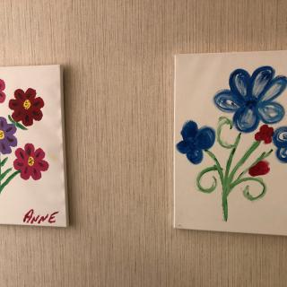 Two colorful floral paintings on a wall.