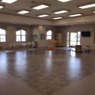 A spacious room with various pieces of furniture and large windows.