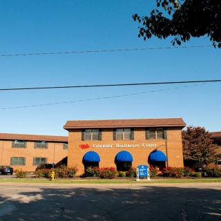 A commercial building with blue awnings and a brick exterior on a sunny day.