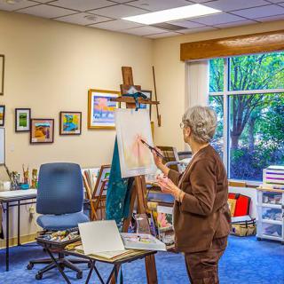 An artist working on a canvas in a cozy art studio.