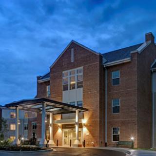 A welcoming hotel exterior illuminated under the evening sky.