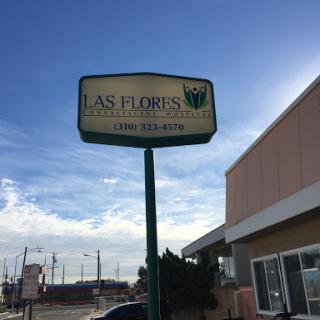 A business sign for 'As Floris' under a cloudy sky.