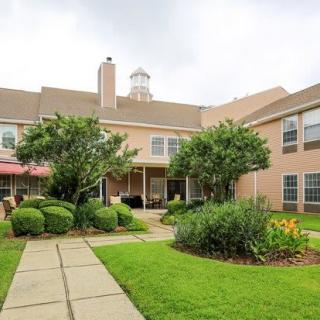 A view of a residential building with a landscaped garden and walkway.